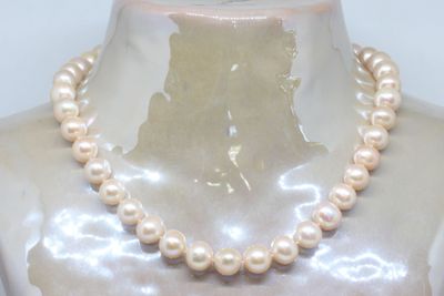 pearl necklace on a mannequin neck with a white background