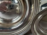 a close up of a silver plate with a person taking a picture