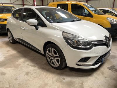 La voiture blanche est garée à côté d'autres voitures dans un garage.