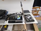 a table with a laptop, a cell phone, and other electronics on it