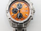 une montre orange et noire montée sur un bracelet en argent