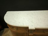 an image of a white marble counter top on a wooden cabinet
