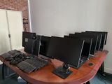 four computer monitors sitting on a desk with a keyboard and mouse