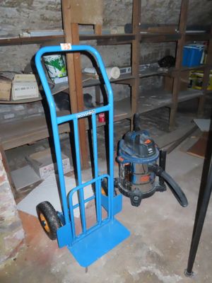un diable bleu et un aspirateur dans une pièce