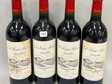 three bottles of red wine are lined up on a table