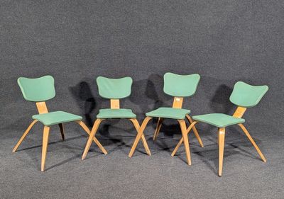 trois chaises vertes placées les unes à côté des autres sur une surface grise