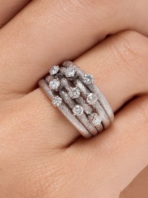 une image représentant la main d'une femme portant une bague en diamant