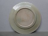 une assiette blanche à bord brun accrochée au mur