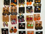 many pairs of earrings on display on the wall