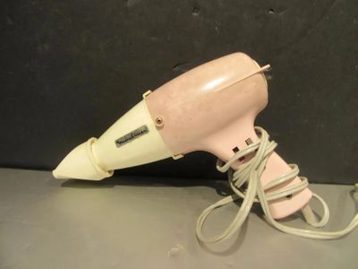un sèche-cheveux rose posé sur une table