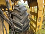 un tracteur immobilisé dans l'herbe, avec un gros pneu
