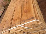 several pieces of wood are stacked on top of each other in front of a building