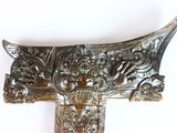 a metal object with a design on it on a white surface