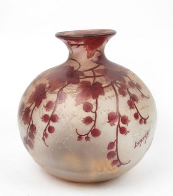 un vase en verre orné de fleurs rouges, posé sur une surface blanche