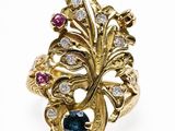 gros plan d'une bague en or avec des pierres bleues et blanches