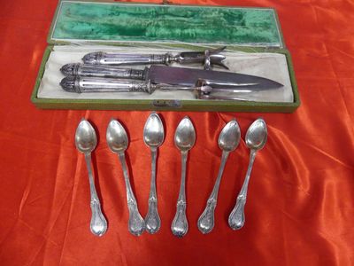 five spoons and a knife in a box on a table