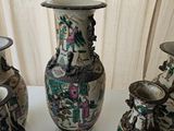 four vases sitting on a white table with a curtain in the background