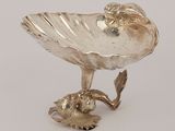an antique silver plate with a bird on top of it