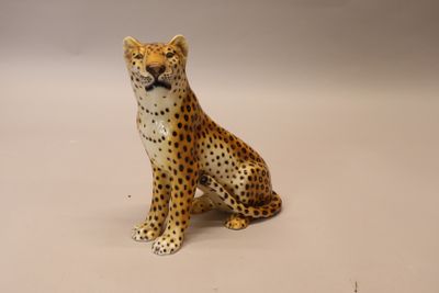 une figurine représentant un guépard assis sur une surface blanche
