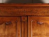 a large wooden armoire with carvings on the top of it