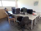 a desk with two computers and a chair in the room