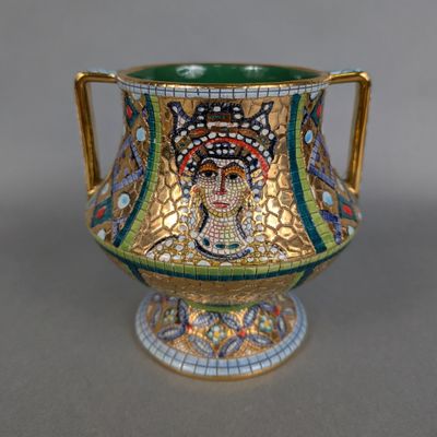 a gold and green vase with a mosaic design on it