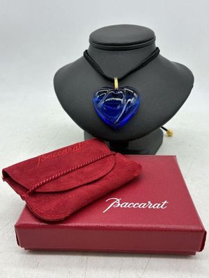 un gros plan d'un collier porté par un mannequin, avec une boîte rouge