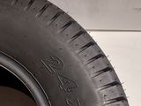 a close up of a tire on the side of a white wall