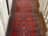 a long hallway with a red rug on the floor