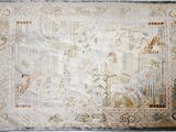 un vieux tapis orné d'un motif d'oiseaux et de fleurs sur fond blanc