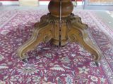 a red rug on the floor next to a wooden table