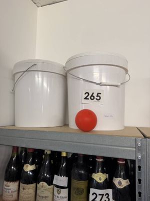 several buckets of wine sit on a shelf in a room