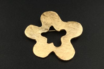un gros plan d'une fleur en métal sur une surface noire