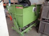 a green dumpster that is sitting in a garage