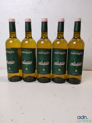 four bottles of white wine are lined up on a table