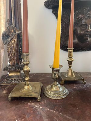 candles are sitting on a table in front of a statue