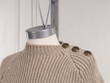 a sweater on a mannequin with a pair of scissors on top of it