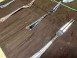 several forks and spoons are lined up in a roll on a table