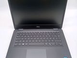 the dell laptop is open and ready to be used on the desk