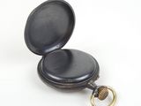 an old black pocket watch with a gold ring on a white background