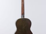 a close up of a guitar hanging on a wall
