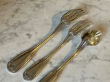 three forks and a spoon on a marble table