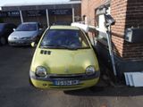 a small yellow car parked in front of a brick building