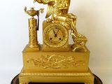une horloge en or surmontée d'un ange