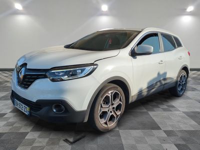 a white car is parked on a checkered floor in a garage