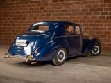 a blue car that is parked in front of a brick wall