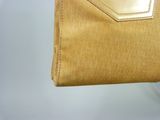someone is holding a gold purse with a chain around it