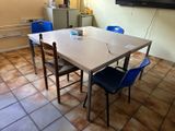 une table et des chaises dans une pièce où une télévision est accrochée au mur