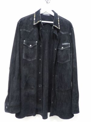 La veste est noire et comporte des clous sur le col.