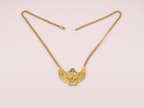 a gold necklace with a green stone on it